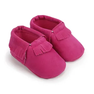 Detailaufnahme von pinkfarbenen Baby-Mokassins aus Wildleder mit modischen Fransen.