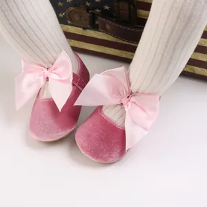 Vue détaillée de chaussures de princesse pour bébé en velours rose avec grands nœuds