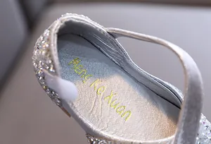 Close-up of girl's silver rhinestone dance shoe with glitter texture