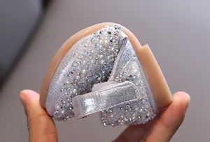 Close-up of silver girls' dance shoes featuring intricate rhinestone and pearl detailing