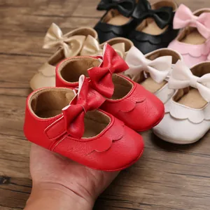 Nahaufnahme roter Baby-Prinzessin-Schuhe mit weicher Sohle, Schleife und Wellenrand-Design