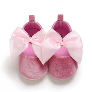 Vue détaillée de chaussures de princesse bébé en velours rose avec grands nœuds