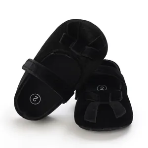 Klassische schwarze Baby-Mary-Janes aus Samt mit hübscher Schleife und weicher Sohle für Babys.