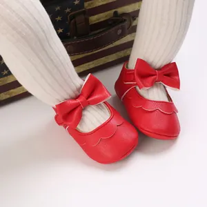 Nahaufnahme roter Baby-Lauflernschuhe mit Schleife und Wellenrand