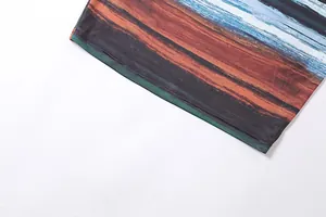 Close-up of the landscape print and fine stitching on a summer bodycon dress hemline