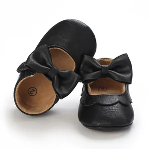 Close-up of black baby girl walker shoes featuring decorative bows and soft soles