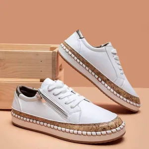 White platform sneakers with decorative cork-style trim and side zipper detail.