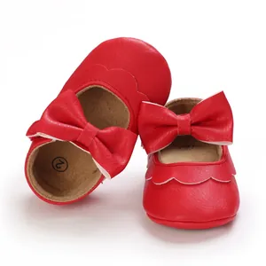 Rote Baby-Lauflernschuhe mit weicher Sohle und dekorativen großen Schleifen auf weißem Hintergrund