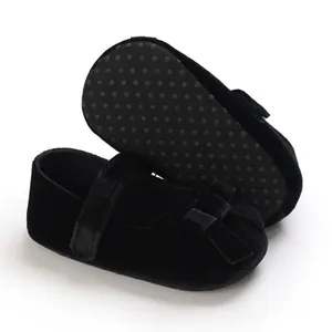 Detailansicht von schwarzen Samtschuhen für Babys mit rutschfester Sohle und Schleifendetail