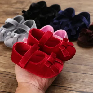 Nahaufnahme von roten Baby-Samtschuhen mit weicher Sohle, Schleife und Klettverschluss