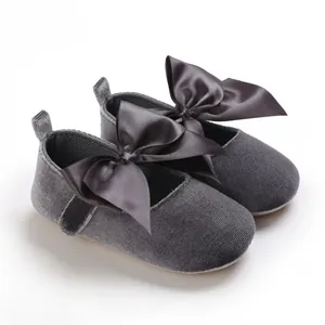 Vue détaillée de chaussures de princesse pour bébé en velours gris avec grand nœud en satin.