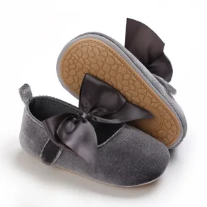 Vista detallada de zapatos de princesa para bebé en terciopelo gris con lazo elegante