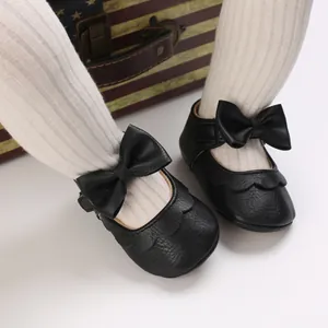 Close-up of black baby princess shoes with bowknot and soft leather texture