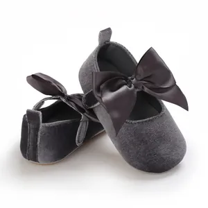 Chaussures de princesse en velours gris pour bébé avec nœud en satin et semelle souple.