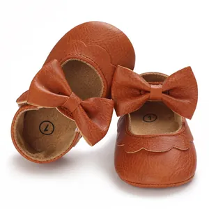 Detailansicht brauner Baby-Lauflernschuhe aus PU-Leder mit dekorativen Schleifen.