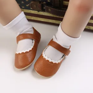 Detailansicht brauner Baby-Prinzessinenschuhe mit weißem Wellenrand und weicher Sohle.