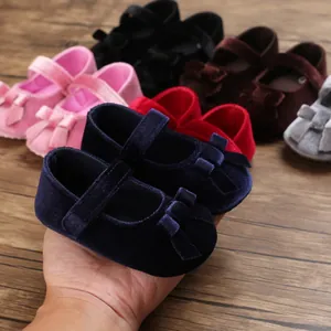 Nahaufnahme von weichen Samt-Babyschuhen mit Schleifendekoration in mehreren Farben