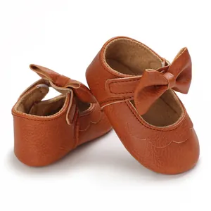 Detaillierte Makroansicht brauner PU-Leder Baby-Prinzessinnenschuhe mit Schleife