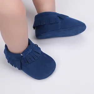 Nahaufnahme von eleganten dunkelblauen Wildleder-Babyschuhen mit Fransen für Neugeborene