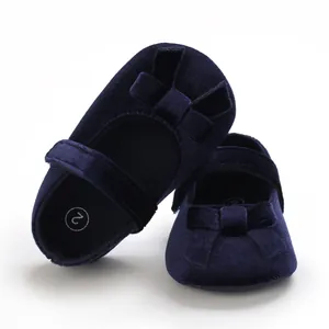 Detailansicht marineblauer Samt-Babyschuhe mit weichen Sohlen und hübscher Schleife.