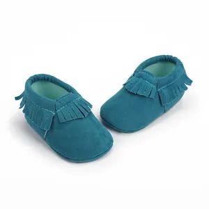Nahaufnahme von türkisfarbenen Wildleder Babyschuhen mit Fransen, weiche Krabbelschuhe