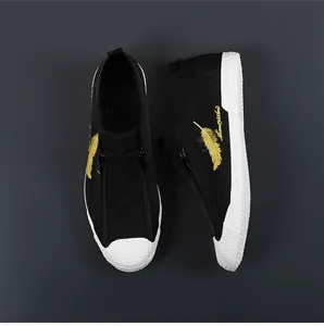 Detailed top view of black breathable mesh sneakers for men with yellow feather embroidery