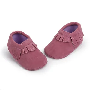 Detailansicht von weichen lila Wildleder-Babymokassins mit modischen Fransendetails