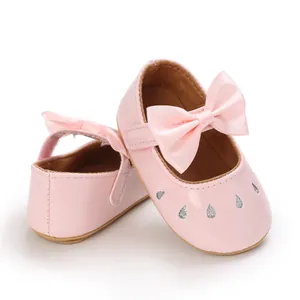 Primer plano de zapatos de princesa rosa para bebé niña con lazo de satén y detalles
