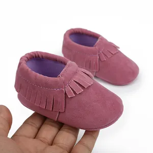 Nahaufnahme von rosa Baby-Lauflernschuhen aus Wildleder mit Fransen und weicher Sohle