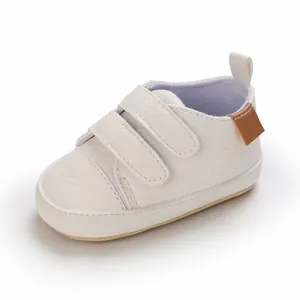 Detailed view of white soft-soled baby walking shoes with hook-and-loop straps