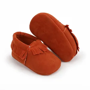 Detailansicht der orangefarbenen Baby-Mokassins aus weichem Wildleder mit Fransen