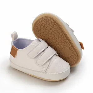 Detailed view of white infant soft-sole pre-walker sneakers with double velcro straps