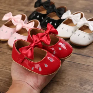 Primer plano de zapatos de bebé tipo Mary Jane con lazos grandes y purpurina de moda