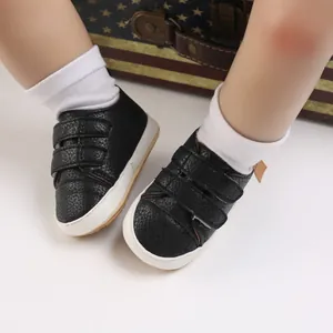 Close-up of black textured faux leather baby walking shoes with velcro straps
