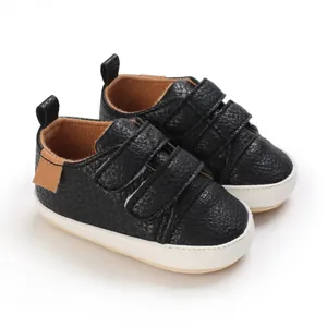 Detailed view of black textured soft-sole baby walking shoes with Velcro straps.