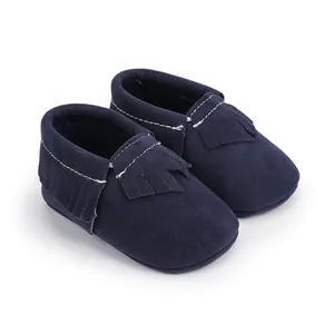 Detail von dunkelblauen Baby-Mokassins aus Wildleder mit weißen Nähten und Fransen.