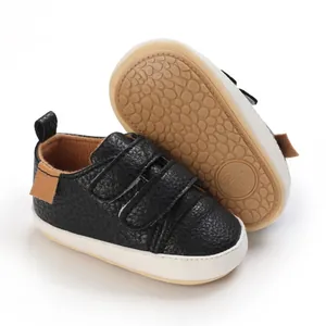Detail of black faux leather baby sneakers showing the textured anti-slip soft sole