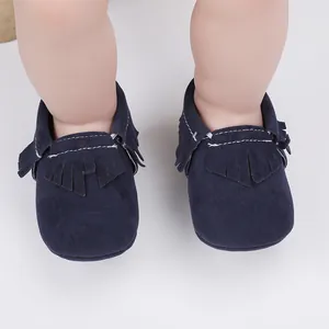 Detailaufnahme von dunkelblauen Baby-Mokassins aus Wildleder mit Fransen und weißen Nähten
