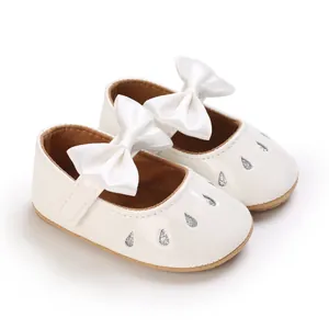 Detalle de zapatos de princesa para bebé niña con lazo de satén y gotas de purpurina.