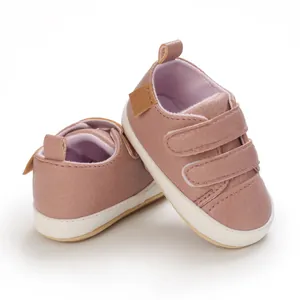 Detail view of pink-brown soft-sole infant walking shoes with double velcro straps
