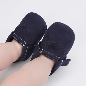 Detailaufnahme von dunkelblauen Wildleder-Babyschuhen mit Fransen und weißen Nähten