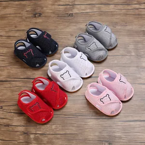 Top view of baby cartoon sandals in five colors on a wooden surface