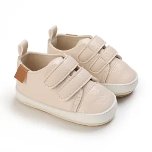 Detailed view of beige infant soft sole walking shoes with double velcro straps