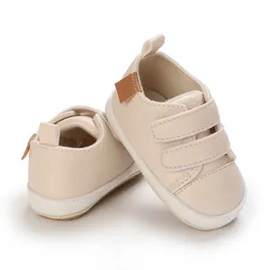 Close-up of beige synthetic leather baby shoes featuring soft soles and velcro straps