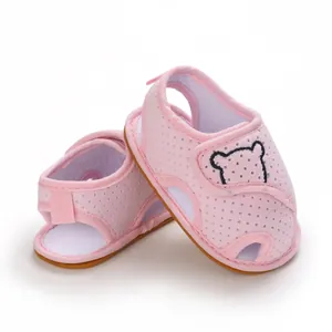 Macro view of pink breathable mesh baby sandals featuring cute cartoon bear embroidery detailing