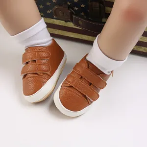 Detailed view of brown PU leather baby walking shoes with dual hook and loop straps.