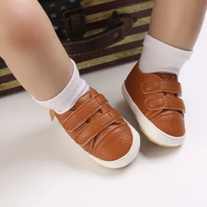 Close-up detail of brown faux leather baby soft sole shoes with dual hook-and-loop straps