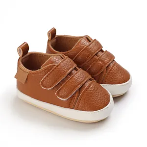 Detailed macro view of brown faux leather baby walker shoes featuring soft soles and velcro