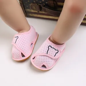 Close-up of pink baby walking sandals with cute bear embroidery and soft mesh fabric.