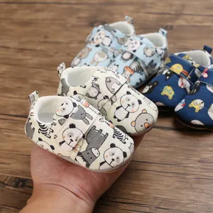 Detail view of cartoon baby pre-walker shoes featuring soft soles and velcro straps.